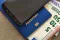 Modern black cellphone, Euro money banknotes bills and travel passport on copy space background. Travelling light, comfortable