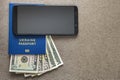 Modern black cellphone, money dollars banknotes bills and travel passport on copy space background. Travelling light, comfortable