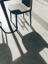 Modern black chairs casting bold geometric shadows on the concrete floor under daylight Royalty Free Stock Photo