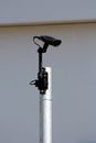 Modern black closed circuit TV CCTV traffic camera connected with single cable and mounted on top of strong metal pole