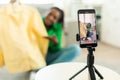Modern black fashion blogger making video review with new shirt, recording video on smartphone, selective focus Royalty Free Stock Photo