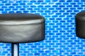 Modern black leather barstool in front of blurred, vigorous-blue small tile background