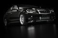 Modern black metallic sedan car in spotlight. Generic desing, brandless. Royalty Free Stock Photo