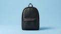 Modern Black Minimalist Backpack on a Light Blue Monochromatic Studio Background Royalty Free Stock Photo