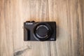 Modern and black pocket camera on a wooden table Royalty Free Stock Photo