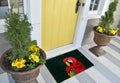 Modern Black Red Parrot / macaws bird printed zute doormat outside home with yellow flowers and leaves Royalty Free Stock Photo
