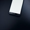 Modern black smart phone isolated on dark background in perspective view. New smartphone mockup with blank touch screen. Royalty Free Stock Photo