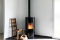 Modern black stove with burning flames and pellet bag in a living room