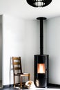 Modern black stove with burning flames and pellet bag in a living room