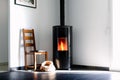 Modern black stove with burning flames and pellet bag in a living room