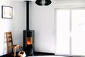 Modern black stove with burning flames and pellet bag in a living room