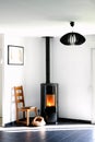 Modern black stove with burning flames and pellet bag in a living room