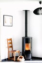 Modern black stove with burning flames and pellet bag in a living room