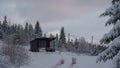 Modern black tiny cabin on Carpathian mountains in Ukraine in fairy tale snowy forest