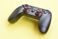 Modern black video game controller on yellow background. Online video game players community concept Royalty Free Stock Photo