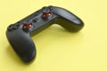 Modern black video game controller on yellow background. Video game speedrun concept or Esports competition challenge Royalty Free Stock Photo