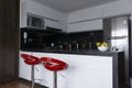 Modern black and white marble kitchen with silver fridge with natural illumination