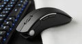 Modern black wireless mouse resting on a keyboard Royalty Free Stock Photo