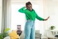 Modern blogging concept. Joyful african american female blogger making video on smartphone, dancing at home Royalty Free Stock Photo