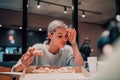 A modern blonde eating pizza in her office on a break from work Royalty Free Stock Photo