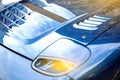 Modern blue car close-up view of headlights and sun rays Royalty Free Stock Photo