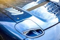 Modern blue car close-up view of headlights and sun rays Royalty Free Stock Photo