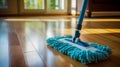 Modern blue mop with microfiber standing on the wooden parquet floor. Process of cleaning room. Concept supporting house hygiene Royalty Free Stock Photo