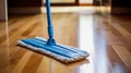 Modern blue mop with microfiber standing on the wooden parquet floor. Process of cleaning room. Concept supporting house hygiene Royalty Free Stock Photo