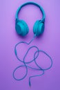 Modern blue wireless headphone on purple background. Music concept.