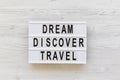 Modern board with text `Dream Discover Travel` word over white wooden background, top view. From above, flat lay Royalty Free Stock Photo