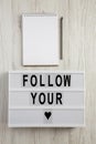 Modern board with text `Follow you heart`, blank notepad over white wooden background. Valentine Day 14 February