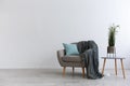 Modern boho cozy corner of home. Gray vintage armchair with blue pillow and blanket Royalty Free Stock Photo