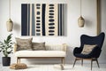 Modern boho interior with black, navy and beige wall art in folk style. Cozy furniture. White sofa and mid century chair.