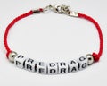 Modern bracelet with names on a red braid on a white background