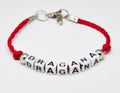 Modern bracelet with names on a red braid on a white background