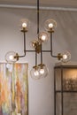 Modern brass chandelier. Pendant lamp with round glass shades and gold-colored copper tubes