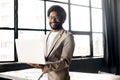 A modern Brazilian businessman smiles while working on his laptop