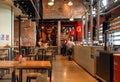 Modern brewery and bar counter with customers buying beer by trademark De Koninck
