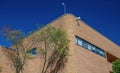 Modern brick building with security cameras and trees. Royalty Free Stock Photo