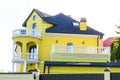 Modern brick yellow private house, building construction with chimney, roof, round balcony with colonies and windows Royalty Free Stock Photo