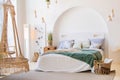 Modern bright bedroom interior with bed, pillows and houseplants Royalty Free Stock Photo