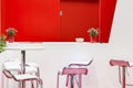 Modern bright red and white room interior with table chairs armchairs