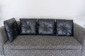 Modern brown fabric sofa with black genuine leather pillows interior decoration Royalty Free Stock Photo