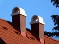 Modern brown stucco finished chimneys with white ceramic cap stones Royalty Free Stock Photo