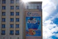 Modern building with big banner with picture background of blue sky and sunlight.