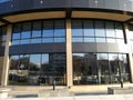 Modern building with city reflections on glass windows.