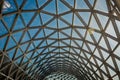 Modern building with curving roof and glass steel column. Gridded geometric abstract background in perspective . Steel structure g