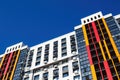 Modern building facade with windows, balconies and boxes for air conditioner on blue sky. Copy space, view at an angle. Royalty Free Stock Photo