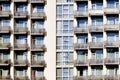 Modern building front wall with repeating pattern of windows and balcony. Royalty Free Stock Photo