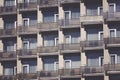 Modern building front wall with repeating pattern of windows and balcony. Royalty Free Stock Photo